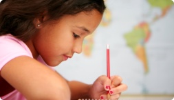 A child writing with a colored pencil