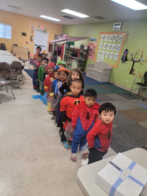 Teacher guiding children through a seated classroom project