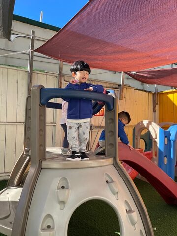 Child exploring the outdoor climbing equipment