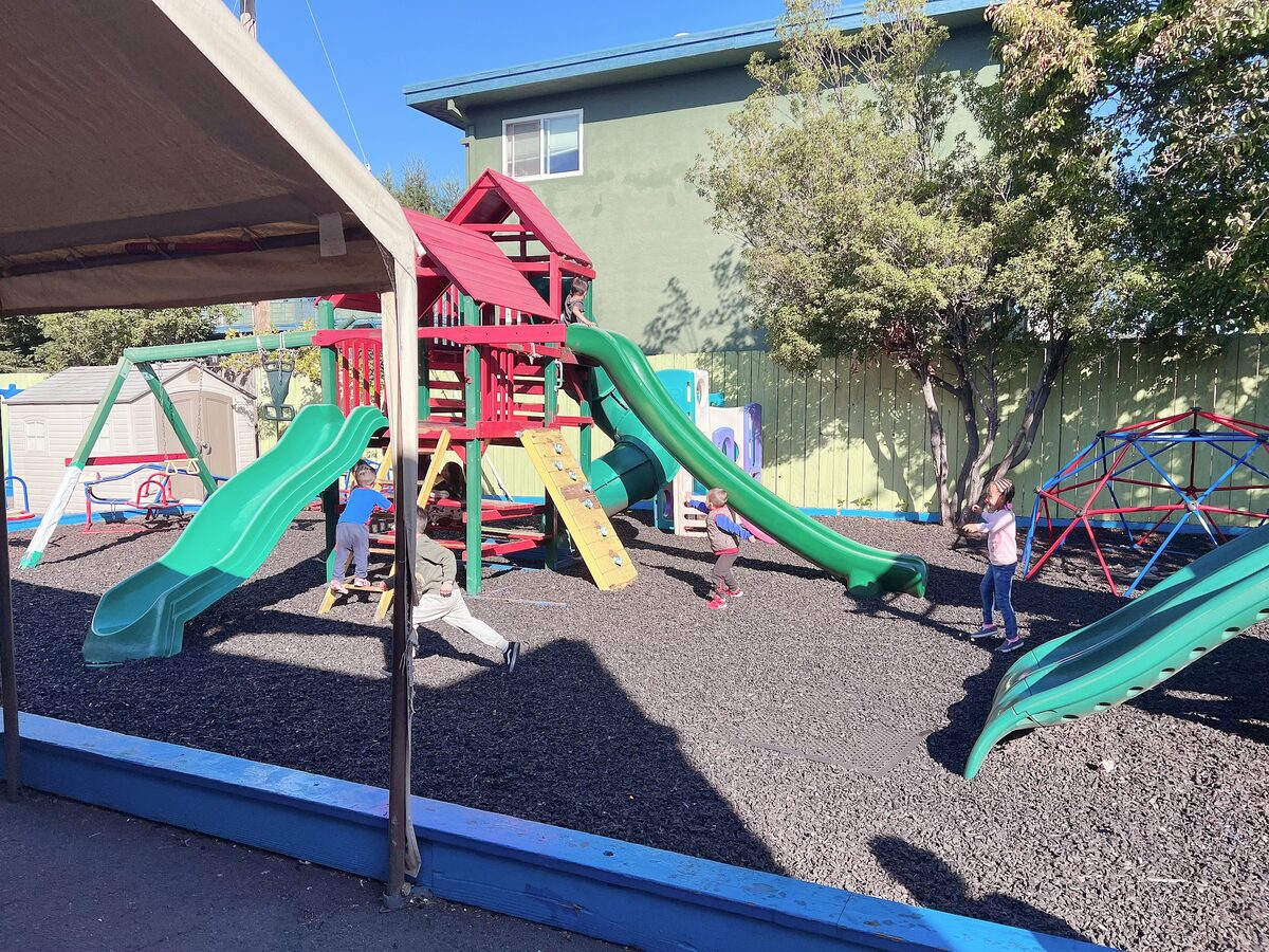 Children climbing and playing on the outdoor play structure
